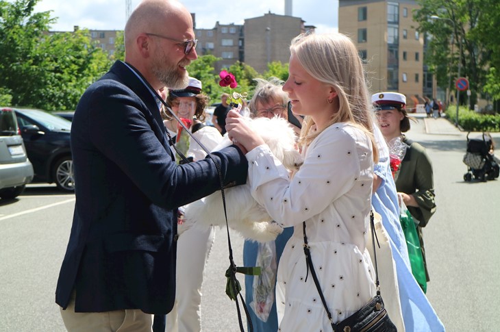 Student lykønskes af far og hund på parkeringspladsen