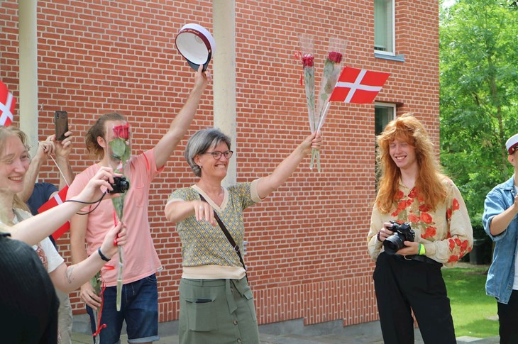 Der viftes med flag og blomster mens studenten kommer ud