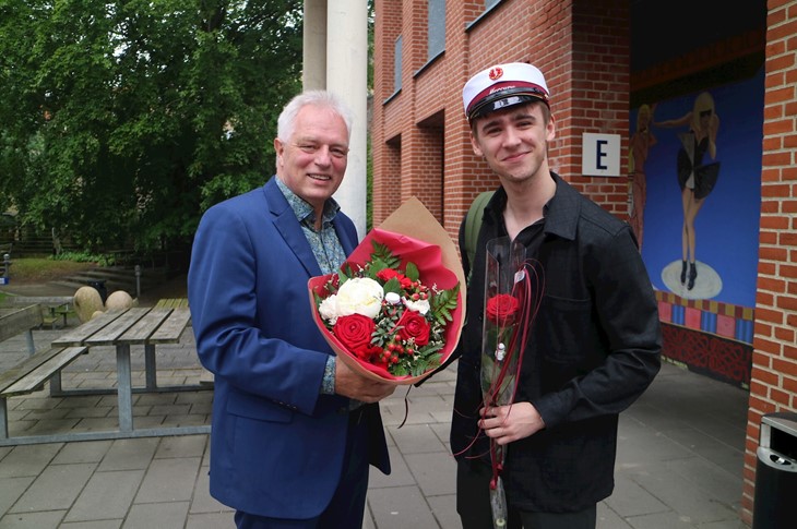 Årets første stx'er - Martin fra 3.d får blomster overrakt af rektor.